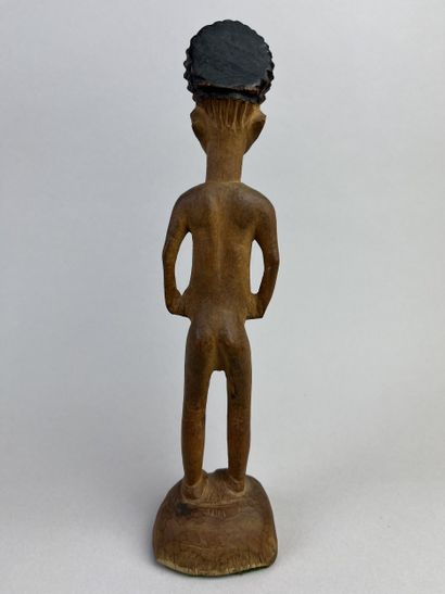 Statuette depicted standing on a round base,...