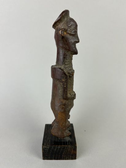 Small fetish with flat headdress, shown standing...