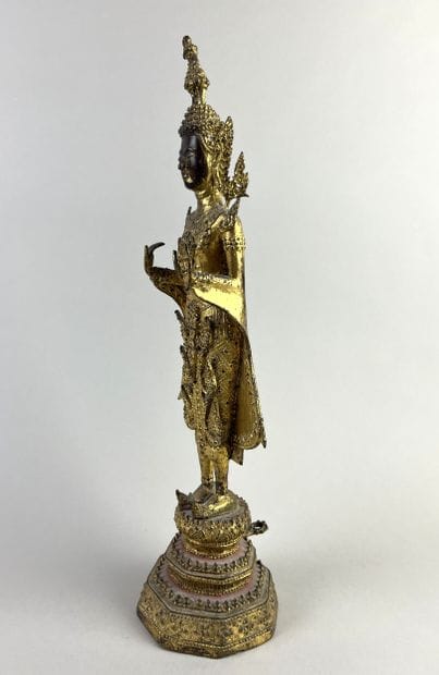 Buddha depicted standing on a pedestal, hands...