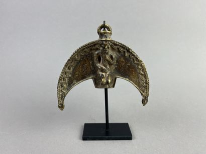 Crescent-shaped pendant featuring a figure...
