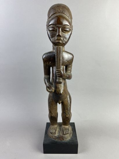 Male ancestor shown standing, holding a long...