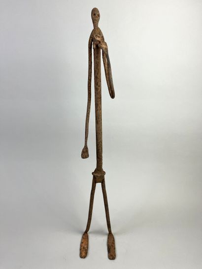 Standing female figure. She is holding her...