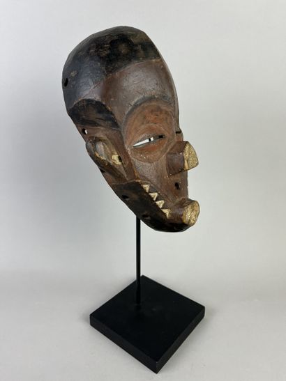 Kindombolo mask. Mask with a human face adorned...