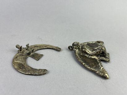 Two crescent-shaped pendants, each decorated...