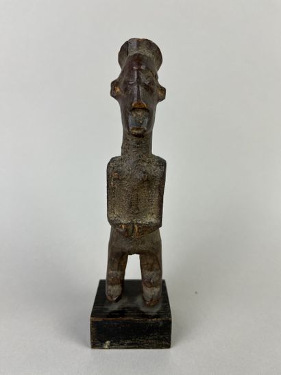 Small fetish with flat headdress, shown standing...