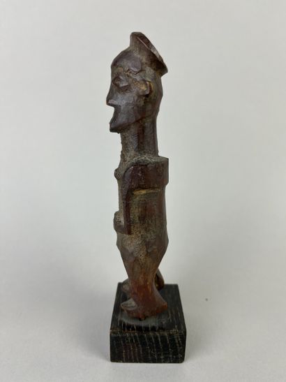 Small fetish with flat headdress, shown standing...
