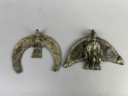 Two crescent-shaped pendants, each decorated...