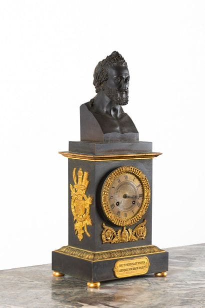 Pendule borne en bronze patiné et doré. Sur...