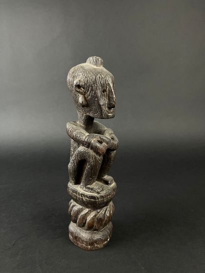 Seated figure with arms resting on knees....