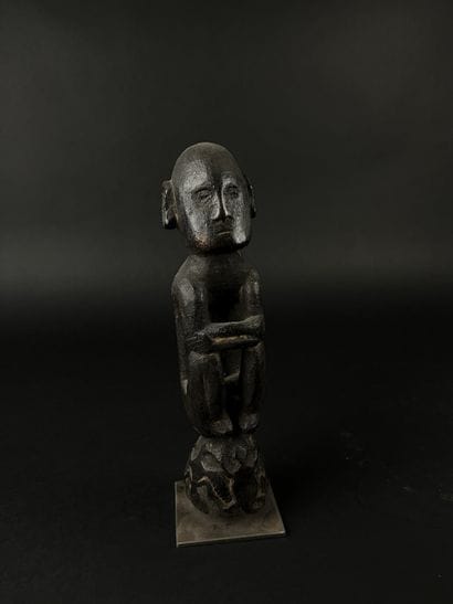 Small seated figure, arms crossed over knees,...