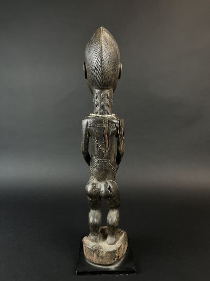 Male statuette depicted standing with arms...