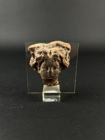 Head from a statuette. Terracotta, lacunae....