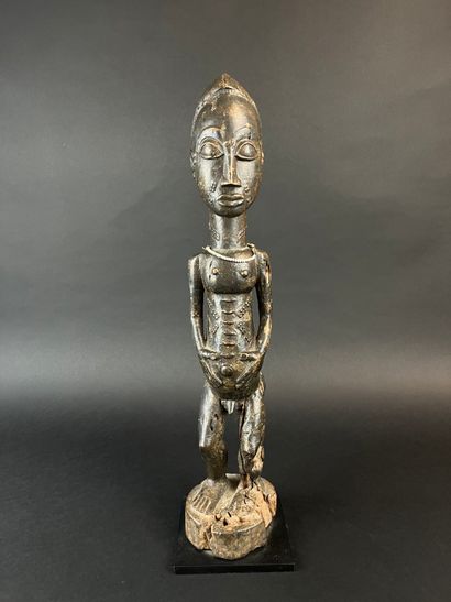 Male statuette depicted standing with arms...