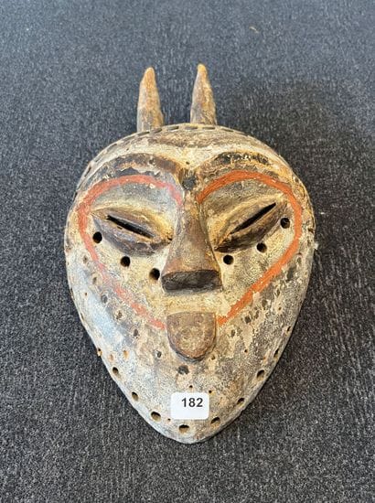 Facial mask. The heart-shaped face is surmounted...