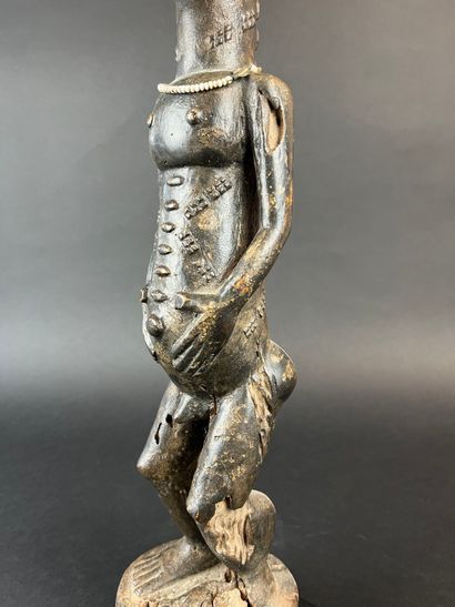 Male statuette depicted standing with arms...