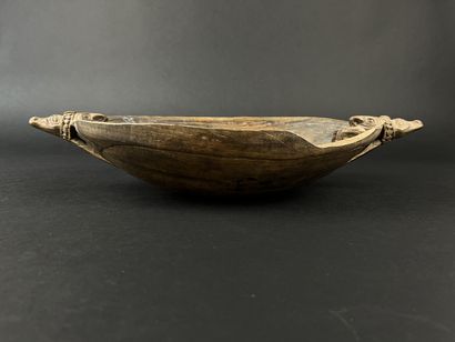 Wooden bowl decorated at the ends with two...