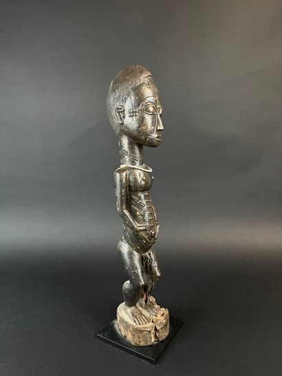 Male statuette depicted standing with arms...