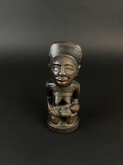 Kneeling mother with child on her lap. Wood...
