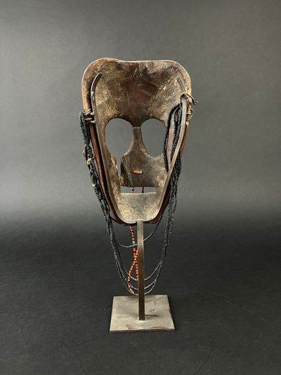 Triangular shamanic mask with a human face,...