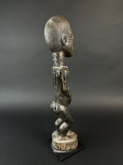 Male statuette depicted standing with arms...