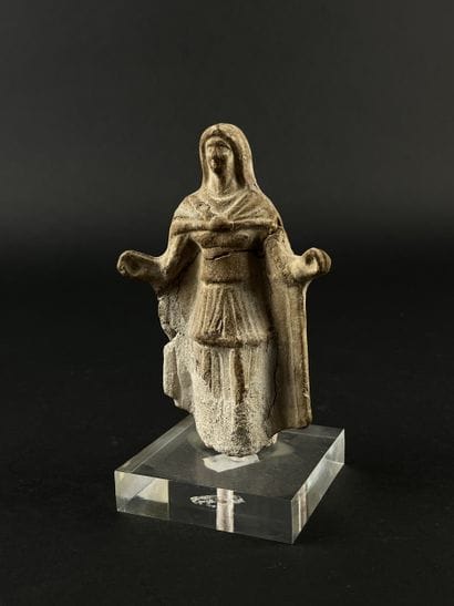 Statuette depicting a cape-clad figure with...