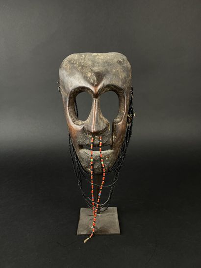 Triangular shamanic mask with a human face,...