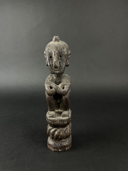 Seated figure with arms resting on knees....