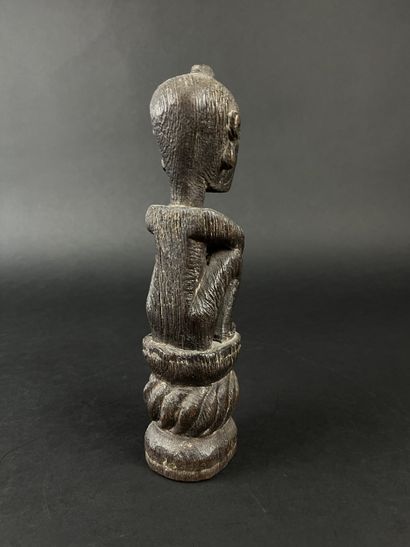 Seated figure with arms resting on knees....