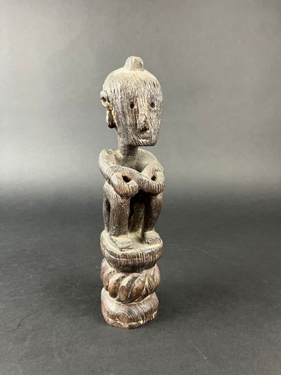 Seated figure with arms resting on knees....