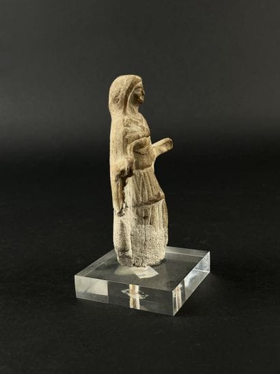 Statuette depicting a cape-clad figure with...
