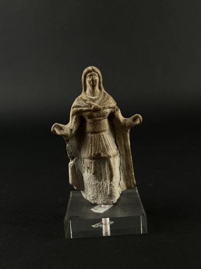 Statuette depicting a cape-clad figure with...