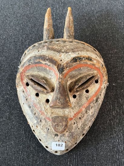 Facial mask. The heart-shaped face is surmounted...