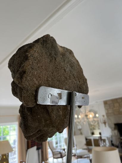 Carved granite head of a saint. Oval-shaped,...