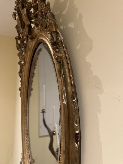 Miroir ovale en bois et stuc doré à décor...