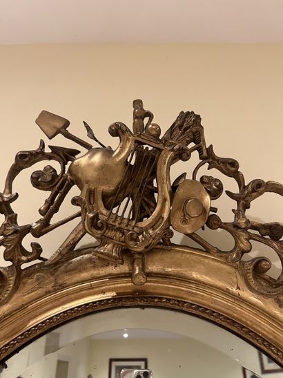 Miroir ovale en bois et stuc doré à décor...