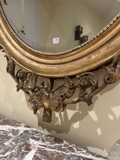 Miroir ovale en bois et stuc doré à décor...