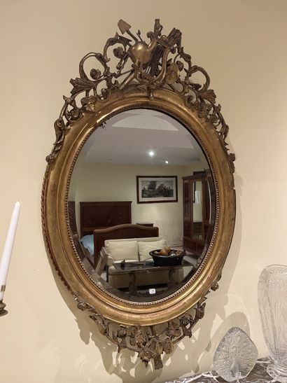 Miroir ovale en bois et stuc doré à décor...