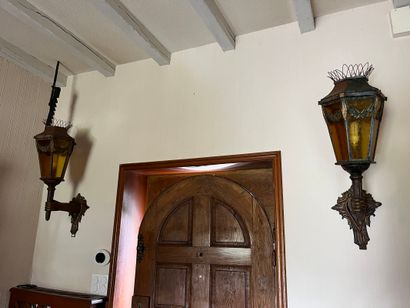 Pair of sconce lanterns held by an arm in...