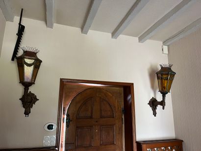 Pair of sconce lanterns held by an arm in...