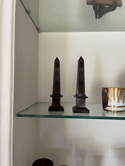 Pair of small obelisks on molded marble base...