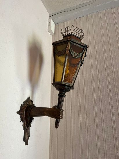 Pair of sconce lanterns held by an arm in...