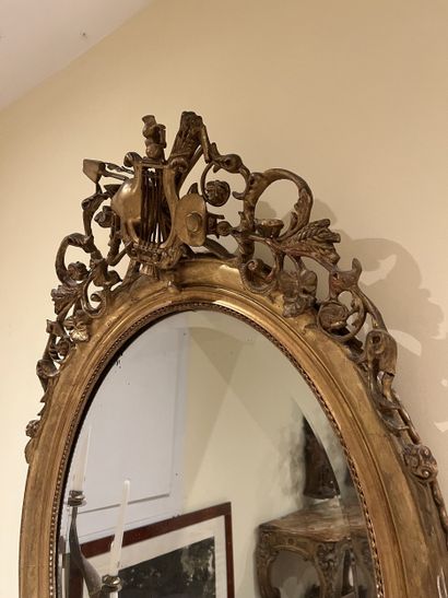 Miroir ovale en bois et stuc doré à décor...