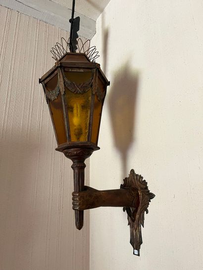 Pair of sconce lanterns held by an arm in...