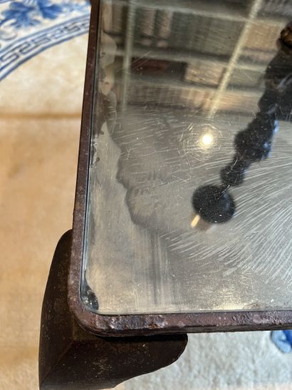 Table basse en fer, le plateau foncé d’un...