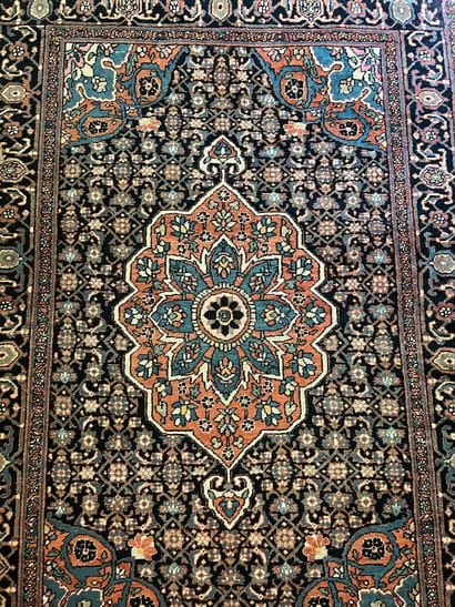 Hand-knotted wool rug decorated with a central...