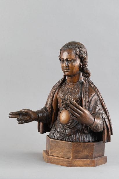 Carved wooden bust of a saintly woman. She...