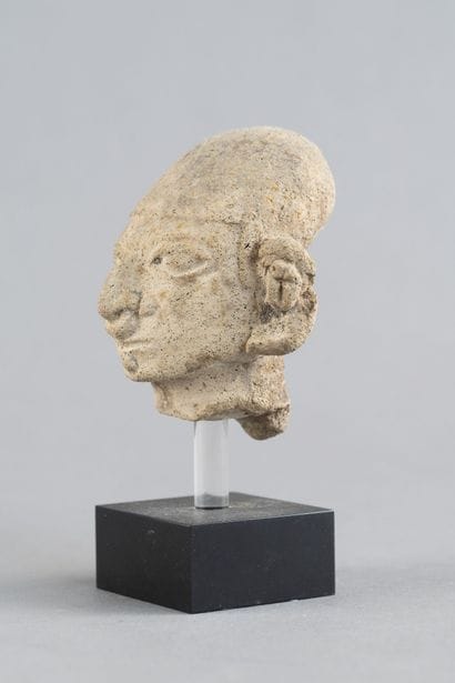 Head of a statuette. It wears a cap and a...