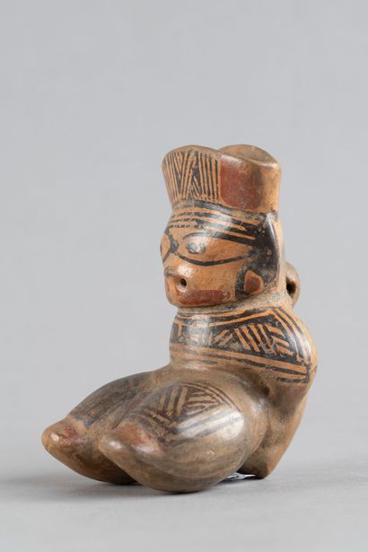 Female statuette depicted in a crouching...