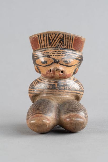 Female statuette depicted in a crouching...