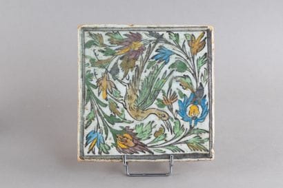 Ceramic tile decorated with a bird entwined...